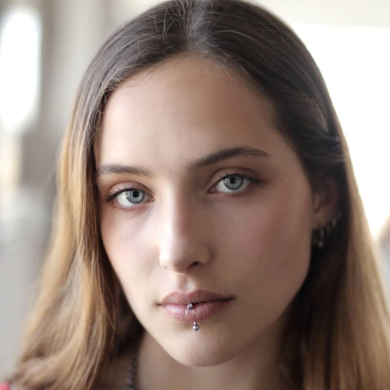 Portrait of a client with a professionally placed facial piercing in a clean studio environment