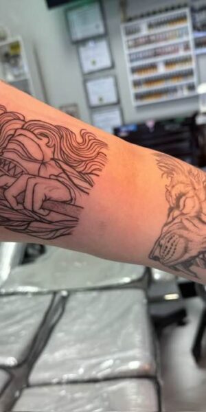 Tattoo in Progress on Arm Tattoo artist working on a detailed arm tattoo during a session