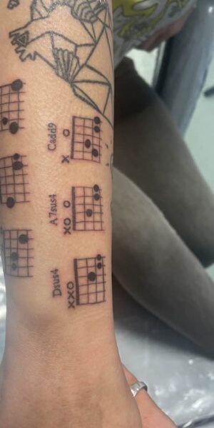 Script and Symbol Tattoo Fine line tattoo featuring script and symbolic elements on the arm