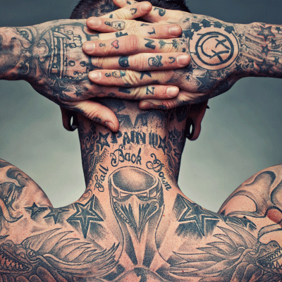 Detailed black and grey tattoo artwork on the upper back and neck created by a professional tattoo artist