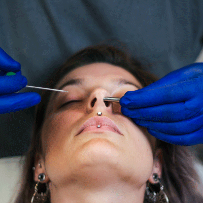Professional nose piercing performed using sterile techniques at a tattoo and piercing studio in Youngsville, Louisiana