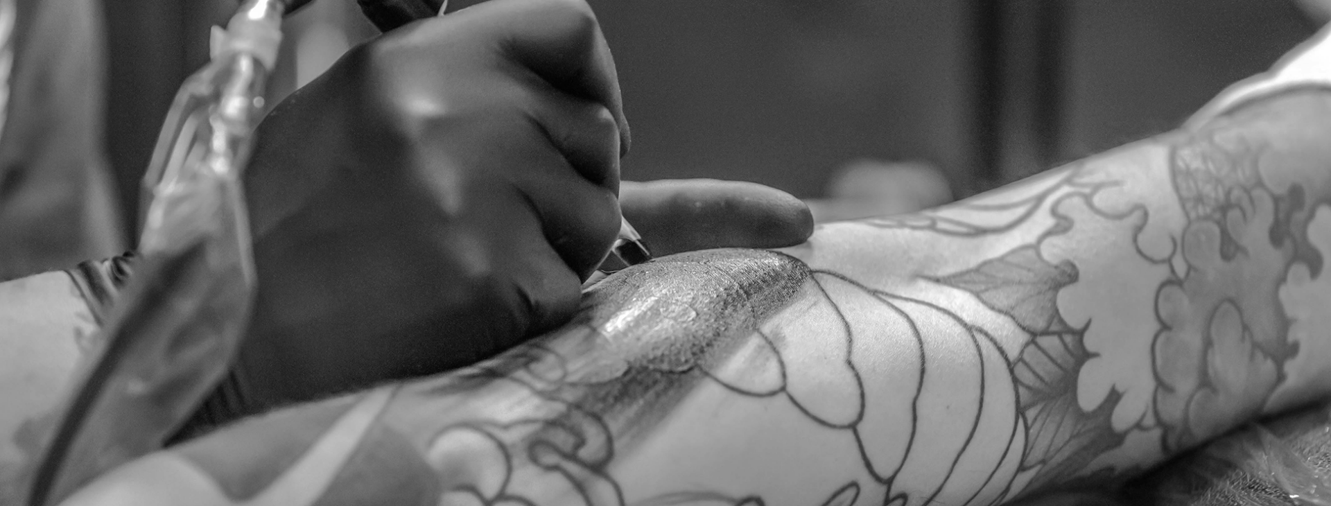 Tattoo artist creating a custom tattoo design using professional equipment during a studio session