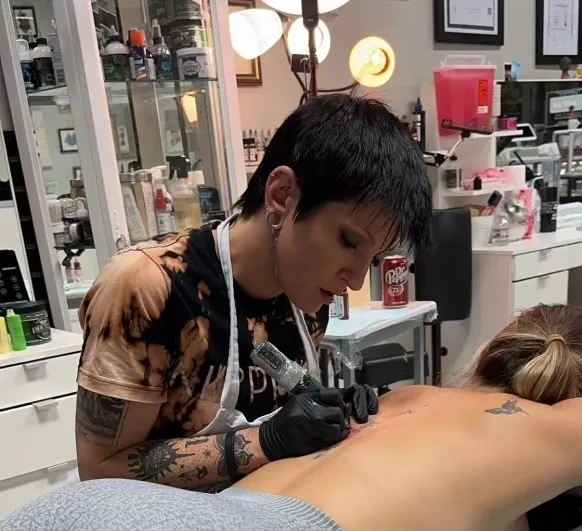 Tattoo artist working on a custom tattoo design in a professional studio