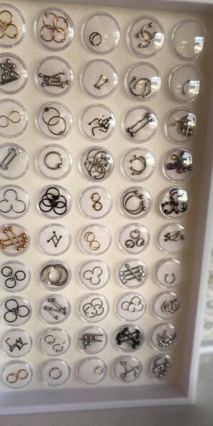 Close-up view of piercing jewelry rings and studs inside display tray