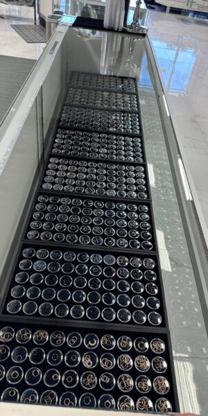 Organized piercing jewelry trays with black ring holders inside Inkophilia studio